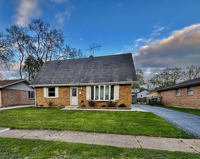 14539 Avers Ave, Midlothian, IL 60445 - cape cod house featuring a front lawn, brick siding, and roof with shingles