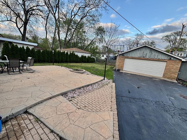14539 Avers Ave, Midlothian, IL 60445 - view of patio featuring a fire pit, a garage, and an outbuilding