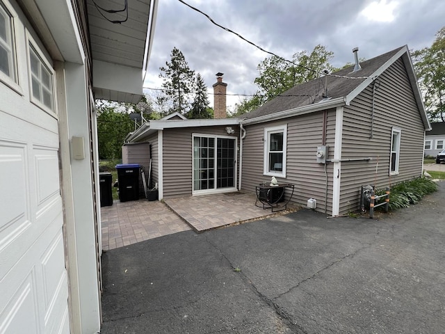 2912 Magellan Dr, Mchenry, IL 60051 - back of property featuring a patio, a chimney, and a shingled roof