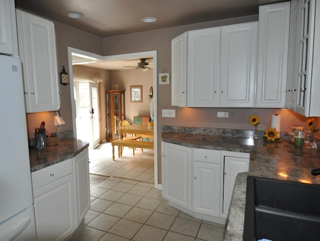 2912 Magellan Dr, Mchenry, IL 60051 - kitchen with freestanding refrigerator, white cabinets, light tile patterned floors, a ceiling fan, and dark countertops