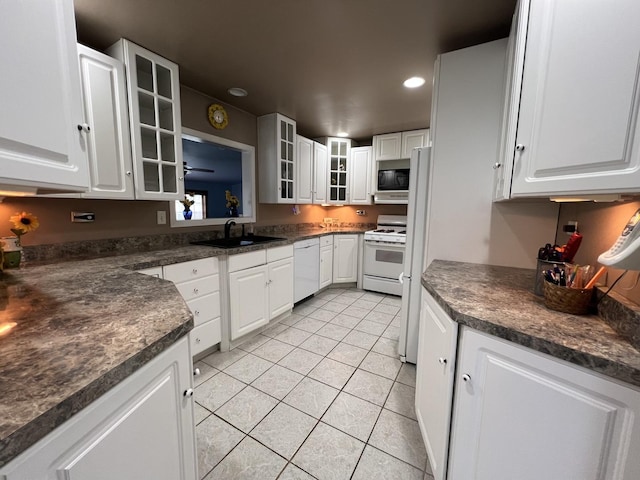 2912 Magellan Dr, Mchenry, IL 60051 - kitchen featuring white appliances, a sink, light tile patterned floors, dark countertops, and recessed lighting