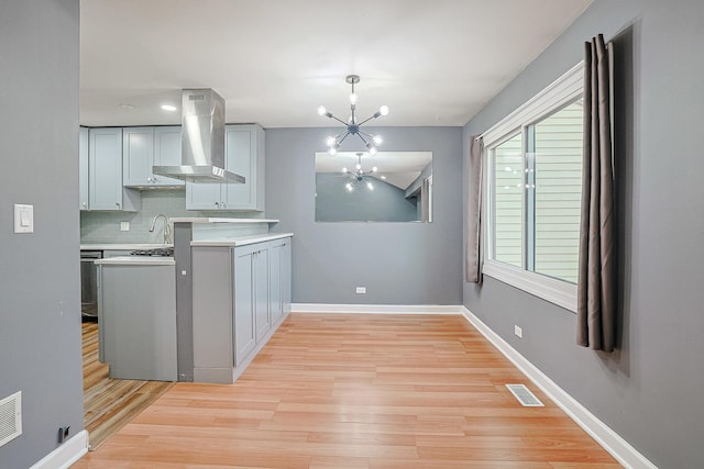 359 Juniper Tree Ct, Hoffman Estates, IL 60169 - kitchen with light countertops, visible vents, wall chimney range hood, light wood-style floors, and a chandelier
