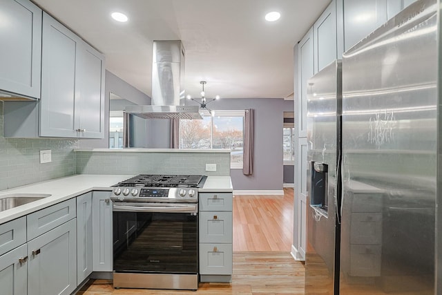 359 Juniper Tree Ct, Hoffman Estates, IL 60169 - kitchen featuring island range hood, backsplash, light wood-style floors, light countertops, and appliances with stainless steel finishes