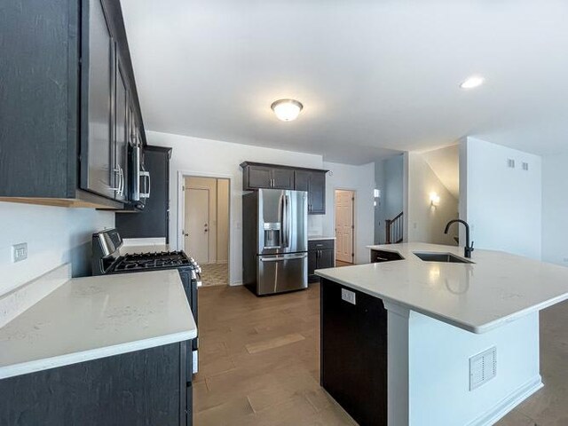 1587 Glenbrooke Ln, New Lenox, IL 60451 - kitchen with light countertops, a kitchen island with sink, appliances with stainless steel finishes, and a sink