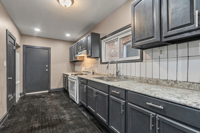 8943 S Lowe Ave, Chicago, IL 60620 - kitchen with a sink, tasteful backsplash, white gas range, under cabinet range hood, and baseboards