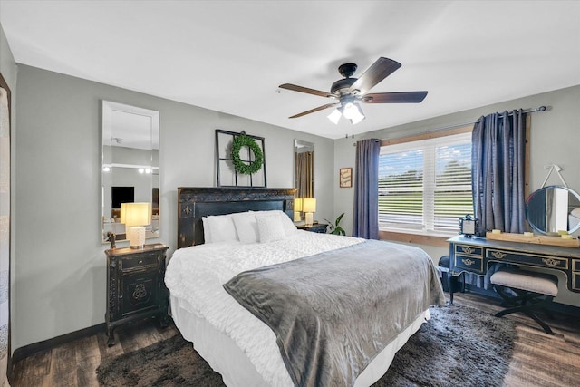 bedroom with dark wood-style flooring, baseboards, and ceiling fan