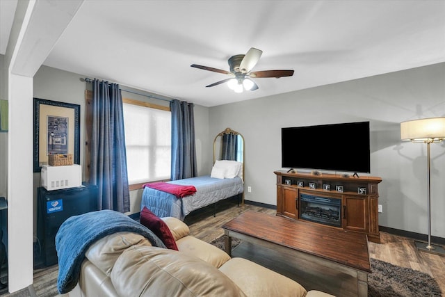bedroom with a ceiling fan, wood finished floors, and baseboards