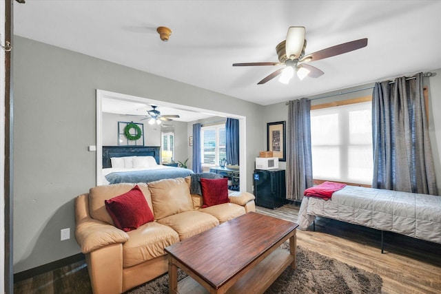 bedroom featuring wood finished floors, a ceiling fan, and multiple windows