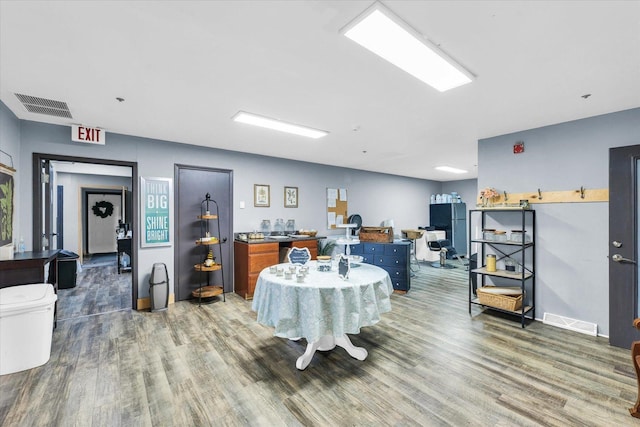 dining room with baseboards, visible vents, and wood finished floors