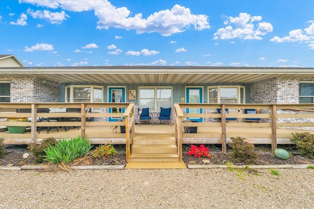 back of property featuring brick siding and covered porch