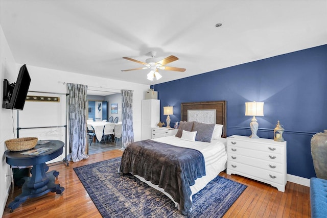 bedroom featuring baseboards, a ceiling fan, and wood-type flooring