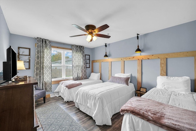 bedroom with ceiling fan, baseboards, and dark wood finished floors
