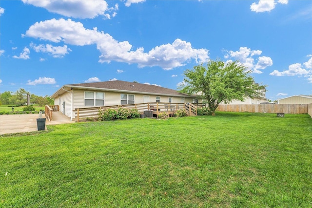 back of house featuring a lawn, a deck, cooling unit, and fence
