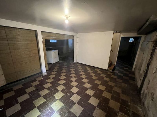 finished basement featuring dark flooring and washer / clothes dryer