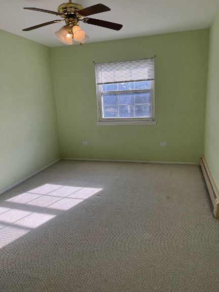 725 Grove Dr Unit 209, Buffalo Grove, IL 60089 - carpeted spare room featuring baseboards, a baseboard heating unit, and ceiling fan