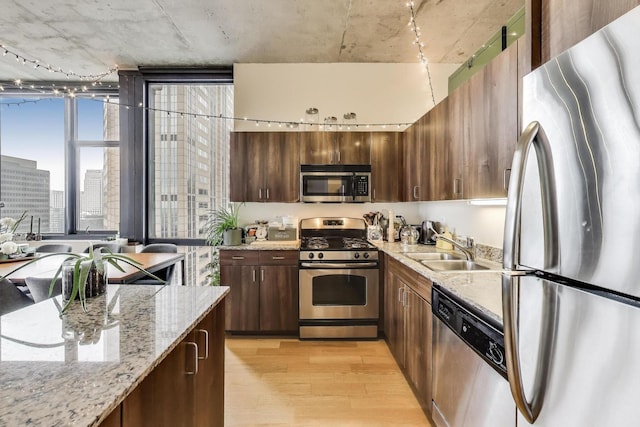 235 W Van Buren St Unit 3414, Chicago, IL 60607 - kitchen featuring appliances with stainless steel finishes, a sink, light wood-type flooring, light stone counters, and a city view
