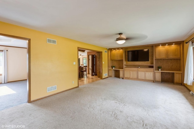 unfurnished living room with light carpet, ceiling fan, and baseboards