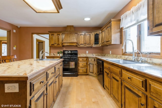 kitchen featuring black appliances, a sink, and brown cabinetry