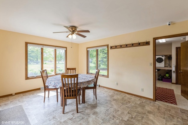 dining space with a ceiling fan, baseboards, and washer and dryer