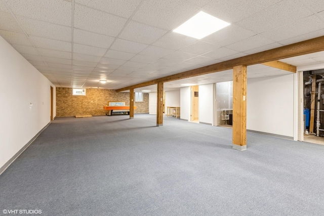 finished basement with carpet floors, baseboards, and a drop ceiling