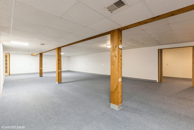 finished below grade area with a drop ceiling, baseboards, and carpet