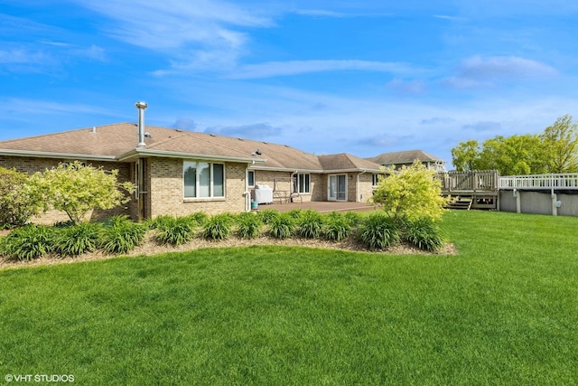view of front of home featuring a patio area, brick siding, a front yard, and a deck