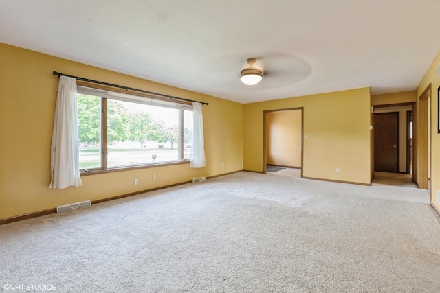 unfurnished room featuring ceiling fan, light colored carpet, and baseboards