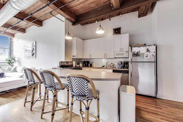 1000 W Washington Blvd Unit 342, Chicago, IL 60607 - kitchen featuring light wood-style flooring, appliances with stainless steel finishes, decorative backsplash, and a kitchen bar