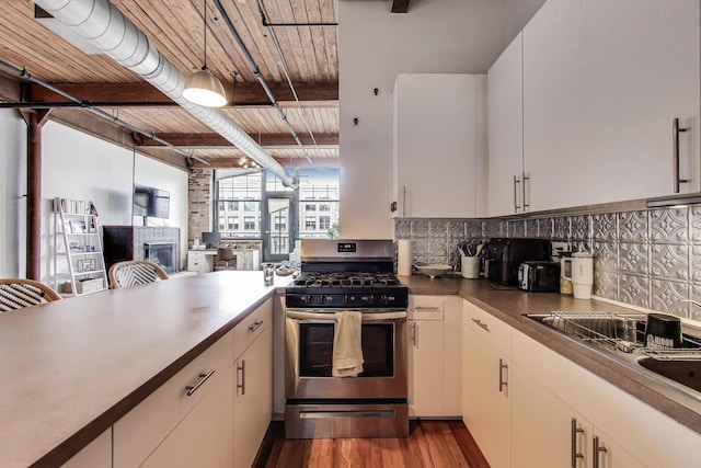 1000 W Washington Blvd Unit 342, Chicago, IL 60607 - kitchen featuring dark wood finished floors, a sink, stainless steel range with gas cooktop, backsplash, and a fireplace