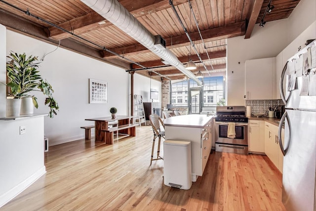 1000 W Washington Blvd Unit 342, Chicago, IL 60607 - kitchen featuring freestanding refrigerator, light wood-type flooring, a kitchen island, stainless steel range with gas cooktop, and beam ceiling