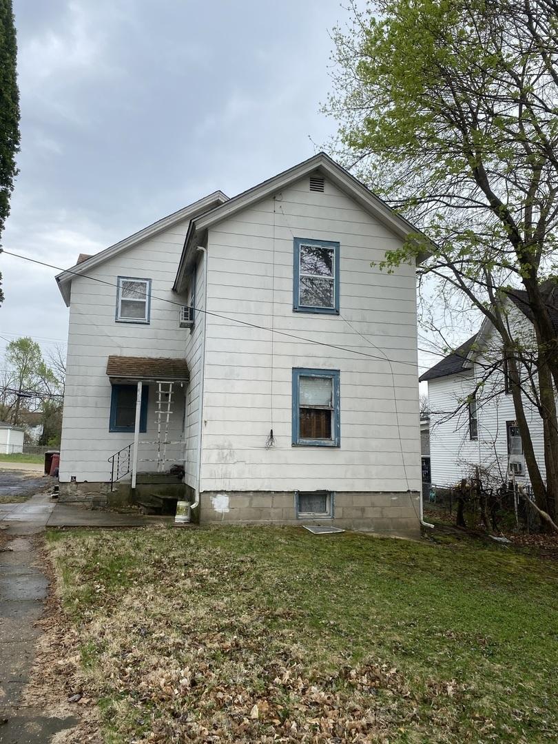 back of property featuring a yard
