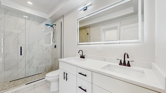 full bath with a sink, double vanity, toilet, and a shower stall