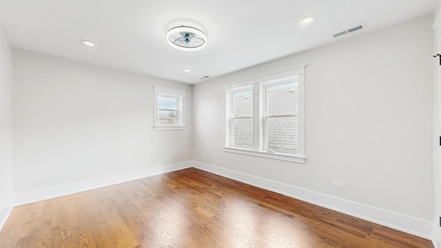 empty room featuring baseboards, recessed lighting, visible vents, and wood finished floors