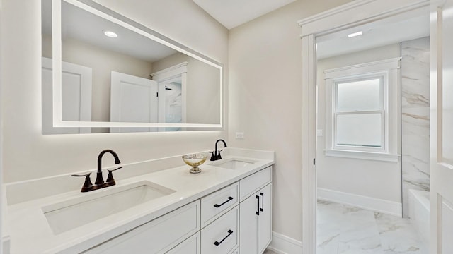 bathroom with a sink, double vanity, baseboards, and marble finish floor