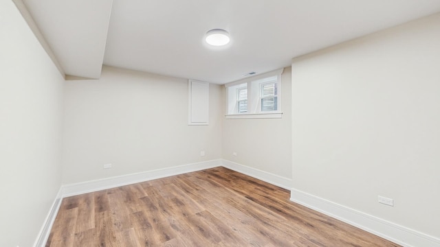 below grade area featuring baseboards, visible vents, and wood finished floors