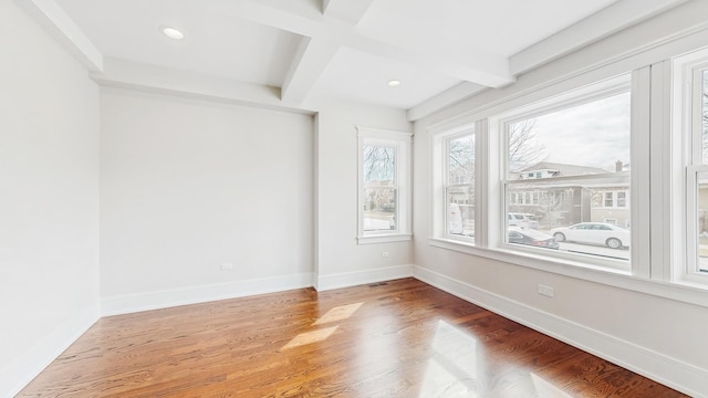 spare room with baseboards, recessed lighting, beam ceiling, and wood finished floors
