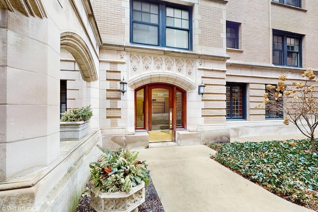 entrance to property featuring stone siding and brick siding