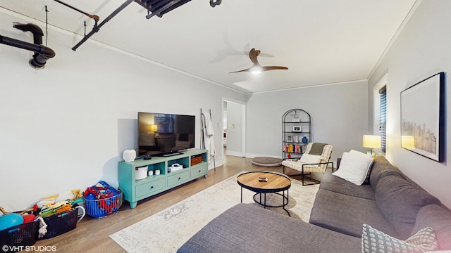 living room with a ceiling fan, crown molding, and light wood-type flooring