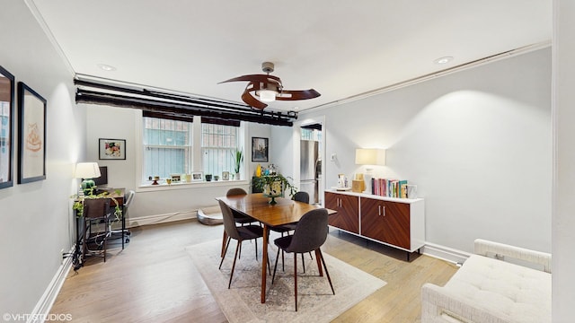 dining area with baseboards, ornamental molding, light wood finished floors, and ceiling fan