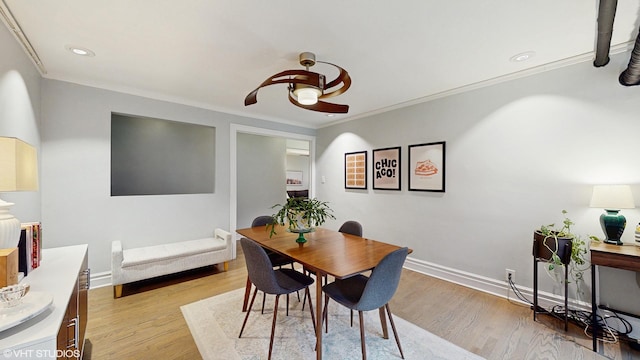 dining area with a ceiling fan, ornamental molding, light wood-style flooring, and baseboards