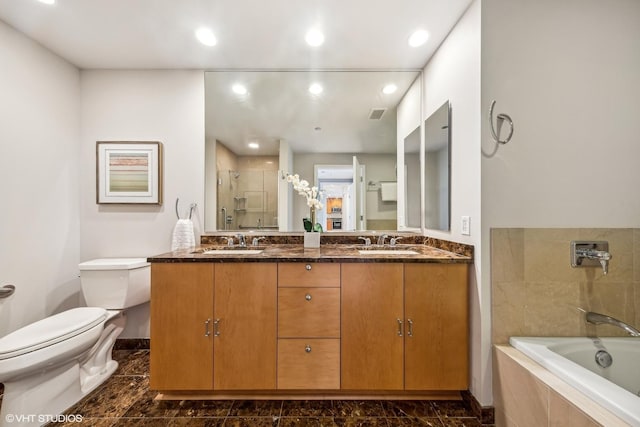 full bathroom featuring double vanity, toilet, a shower stall, and a sink