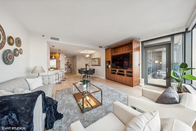 living area featuring light wood-style flooring and visible vents