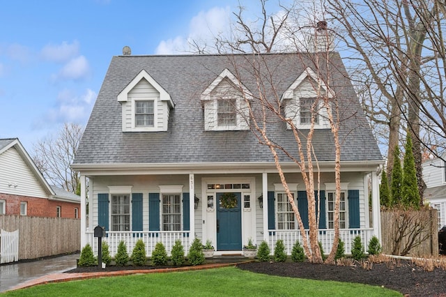 cape cod home with a porch and roof with shingles