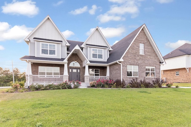 craftsman-style home with board and batten siding, a porch, brick siding, and a front lawn