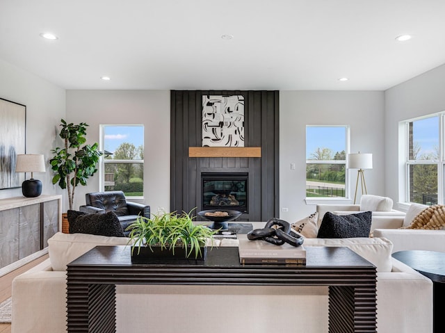 living area with a fireplace, wood finished floors, and recessed lighting