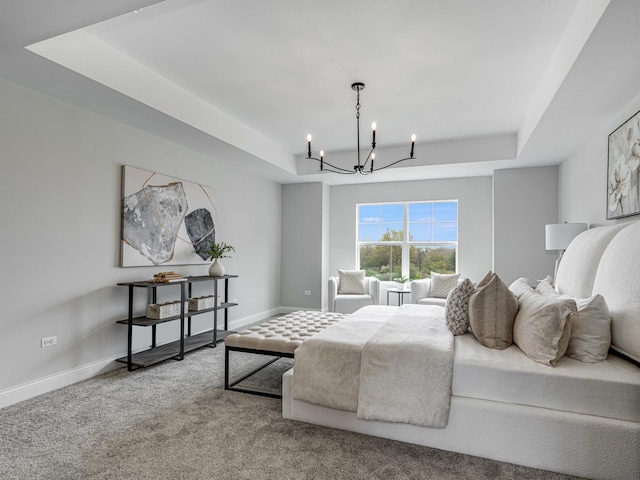 bedroom featuring an inviting chandelier, a raised ceiling, baseboards, and carpet