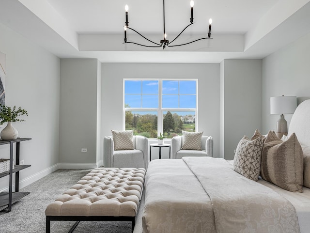 carpeted bedroom with baseboards, a notable chandelier, and a raised ceiling