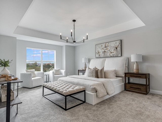 carpeted bedroom with baseboards, a notable chandelier, and a raised ceiling