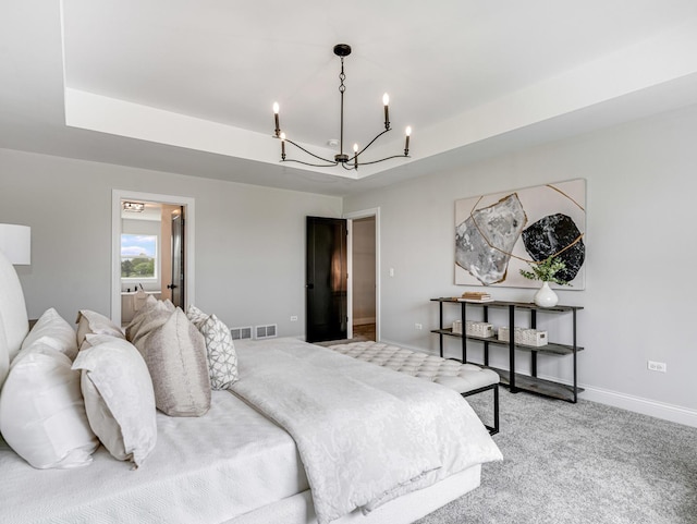 bedroom with visible vents, light carpet, baseboards, a tray ceiling, and a chandelier