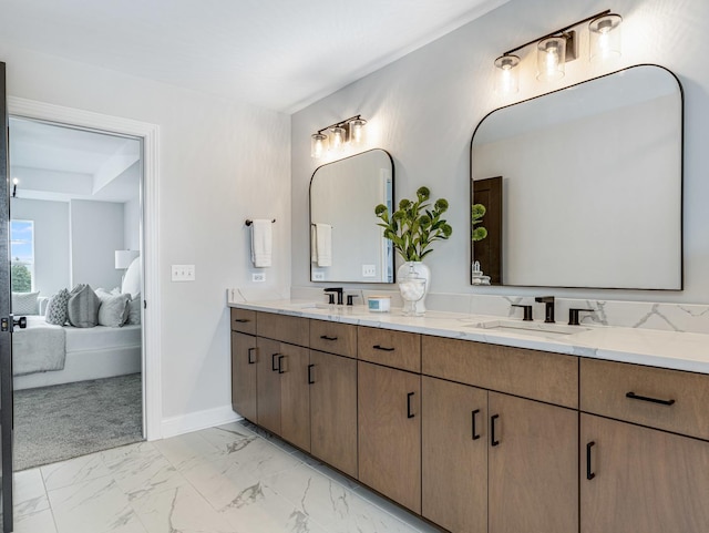 bathroom featuring double vanity, a sink, baseboards, marble finish floor, and ensuite bath